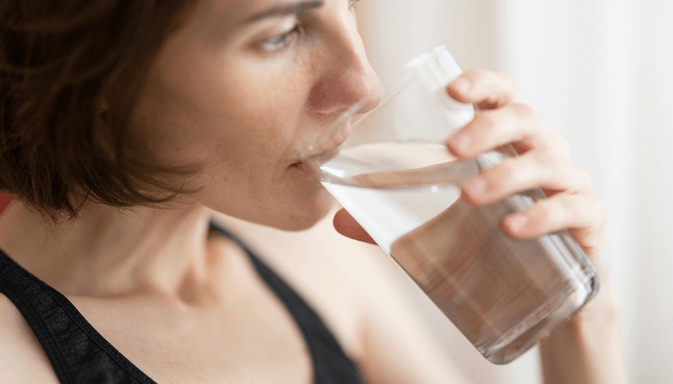 Mujer bebiendo agua para combatir el calor y controlar su glucosa
